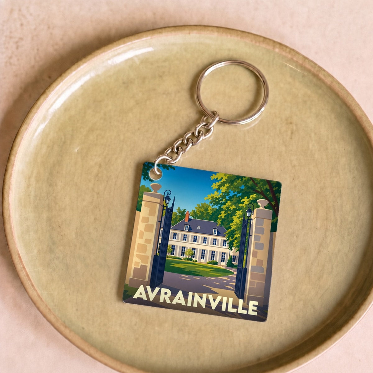 Porte-clés souvenir de la ville d'Avrainville avec une illustration stylisée de son patrimoine.