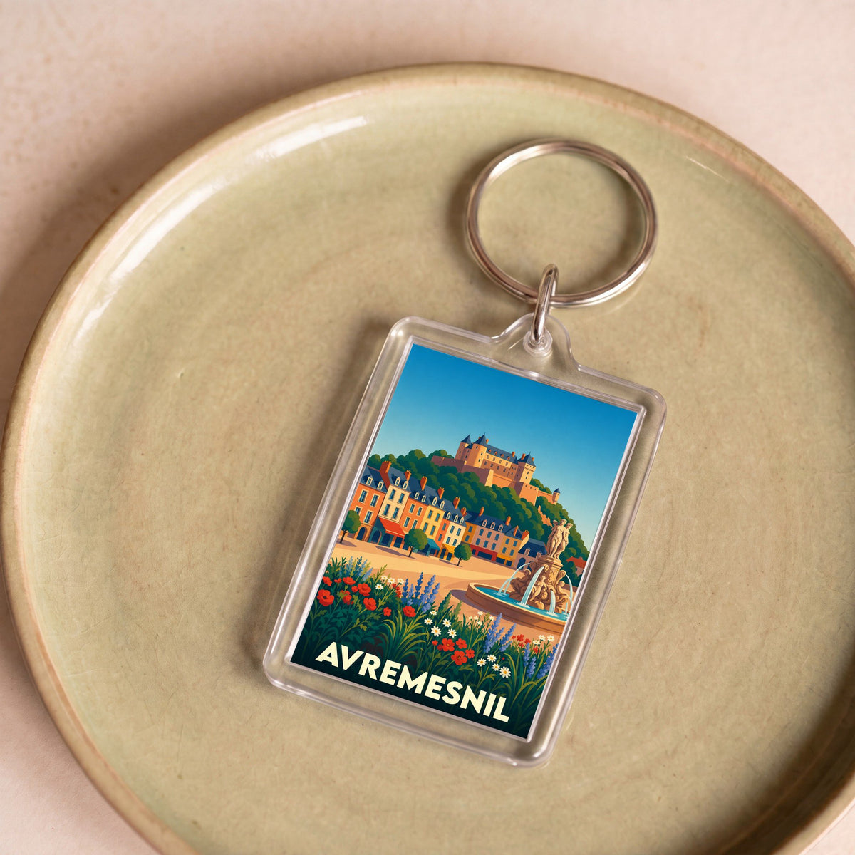 Porte-clés souvenir de la ville d'Avremesnil avec une illustration stylisée d'un paysage urbain.