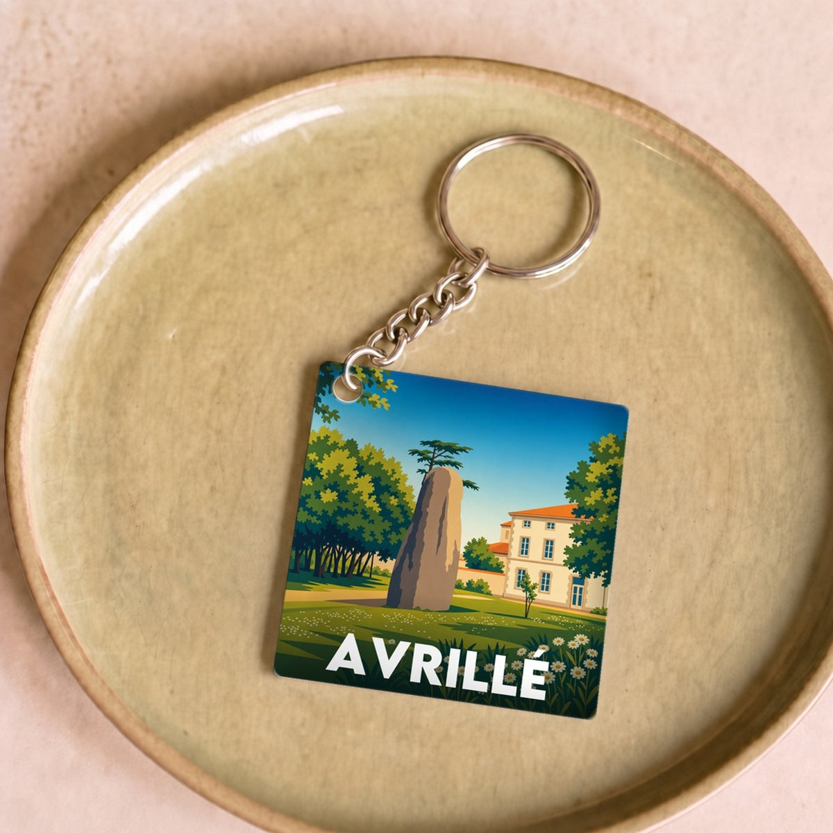 Porte-clés souvenir de la ville d'Avrillé avec une illustration stylisée.