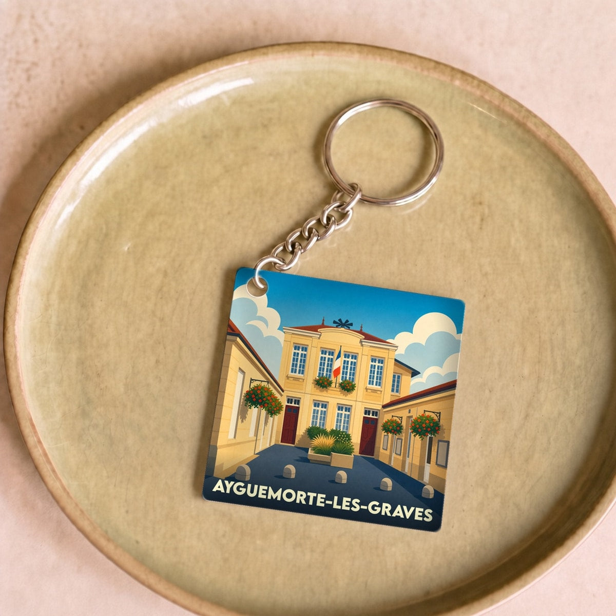 Porte-clés souvenir de la ville de Ayguemorte-les-Graves avec une illustration stylisée.