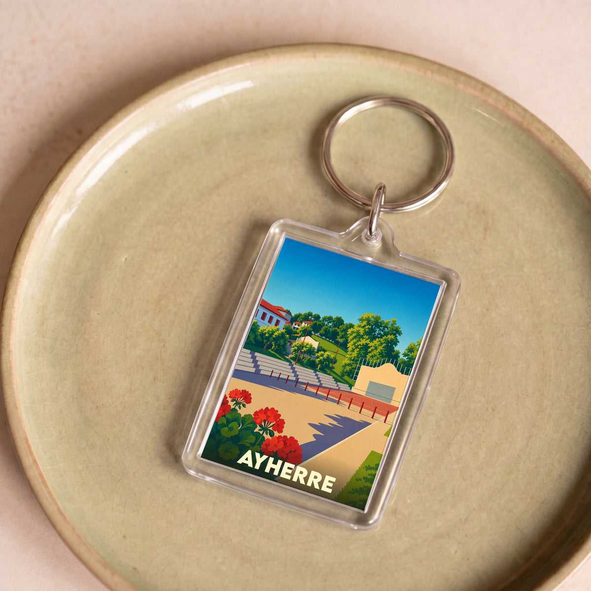 Porte-clés souvenir de la ville de Ayherre avec une illustration stylisée d'un fronton de pelote basque.