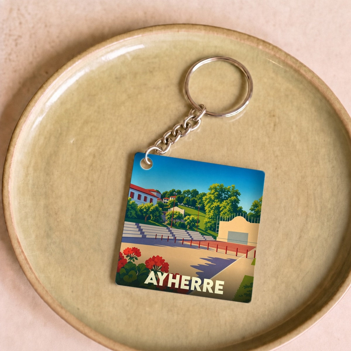 Porte-clés souvenir de la ville de Ayherre avec une illustration stylisée d'un fronton de pelote basque.