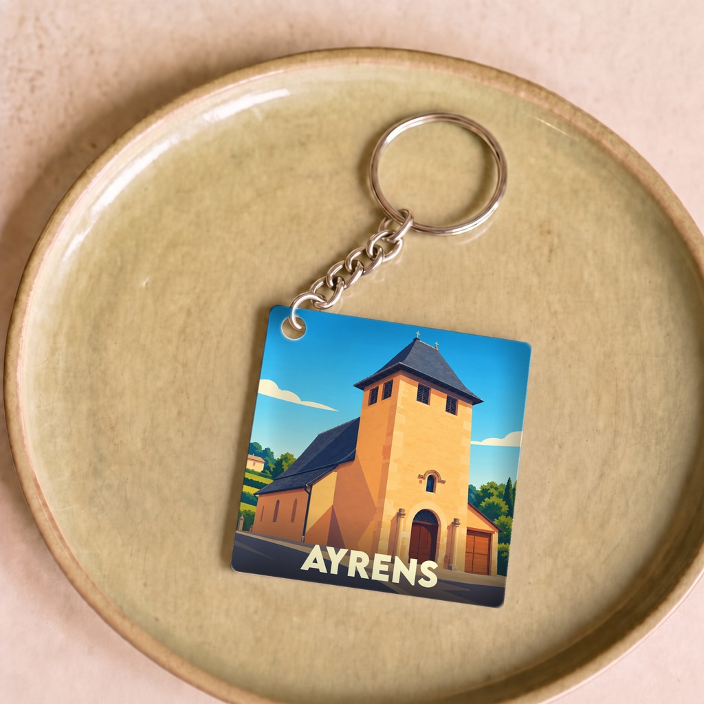 Porte-clés souvenir de la ville d'Ayrens avec une illustration stylisée de son église.