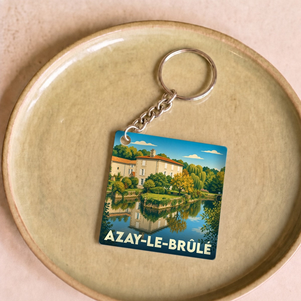Porte-clés souvenir de la ville d'Azay-le-Brûlé avec une illustration stylisée.