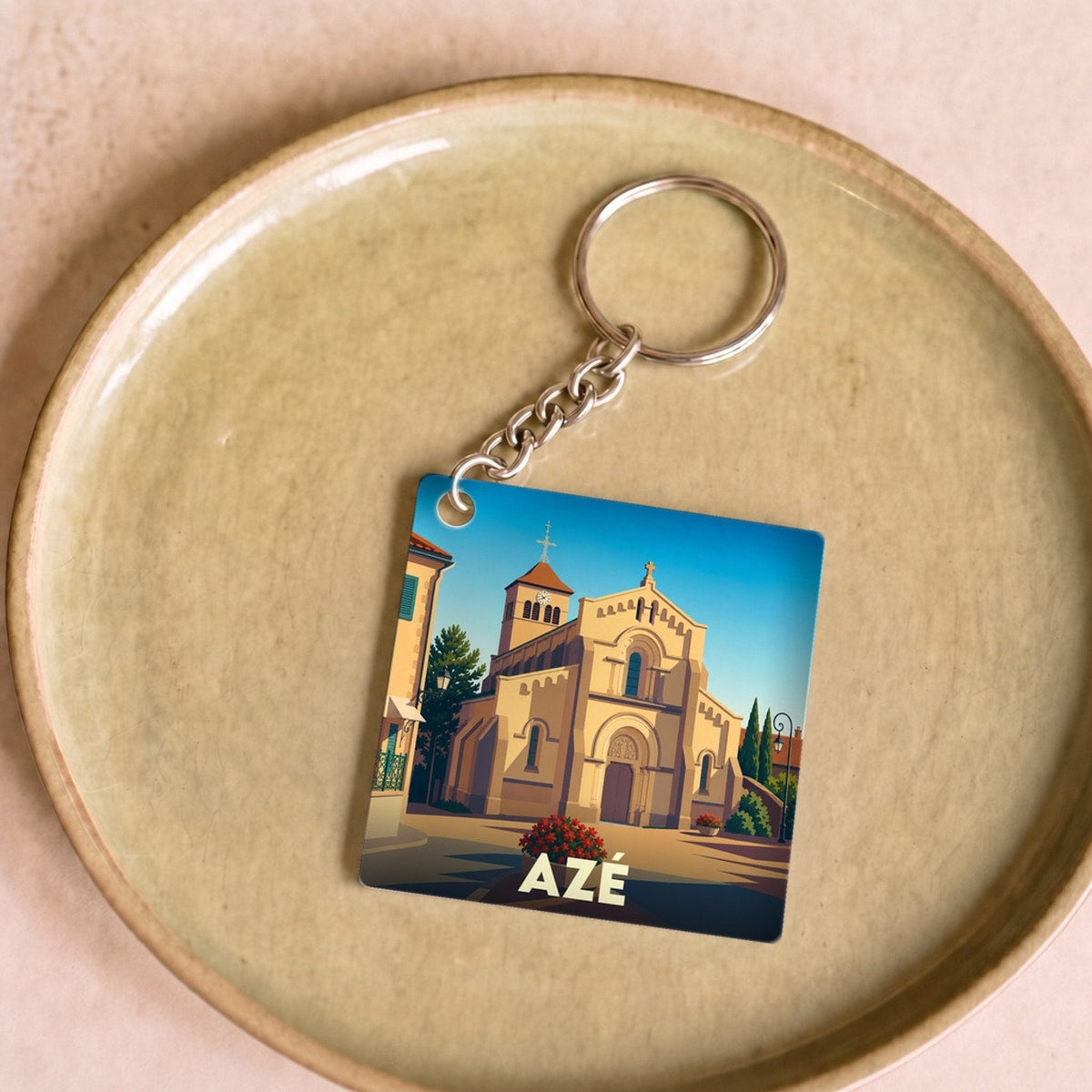 Porte-clés souvenir de la ville d'Azé avec une illustration stylisée de son église.