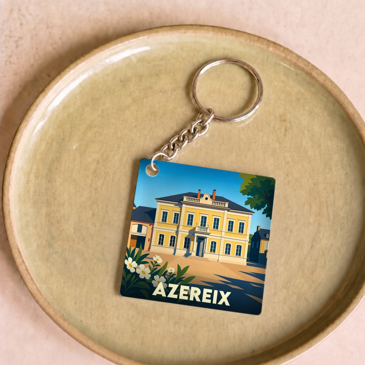 Porte-clés souvenir de la ville d'Azereix avec une illustration stylisée.