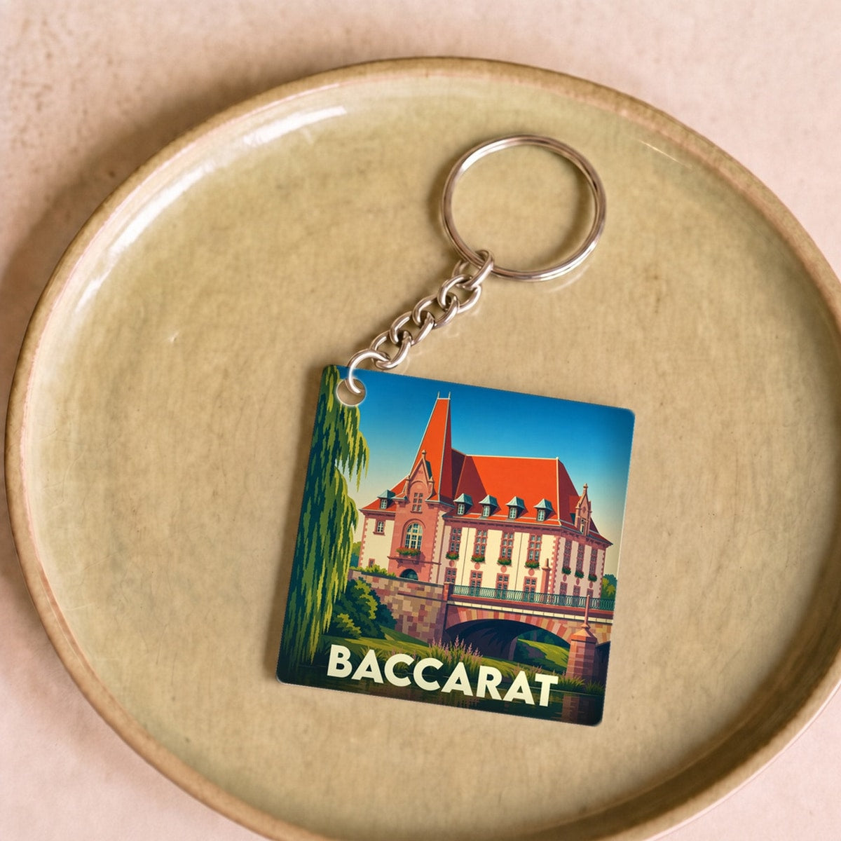 Porte-clés souvenir de la ville de Baccarat avec une illustration stylisée.