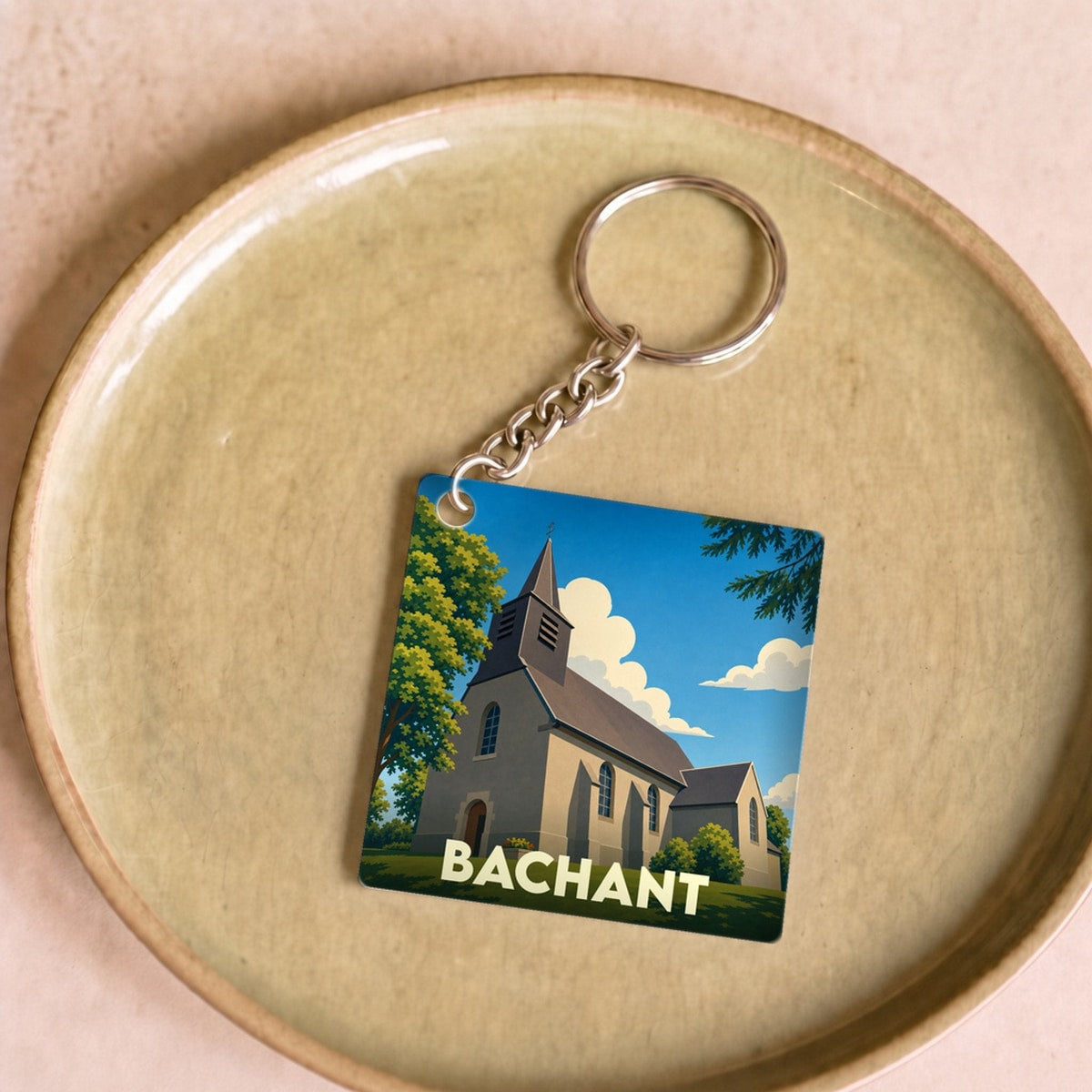 Porte-clés souvenir de la ville de Bachant avec une illustration stylisée de son église.
