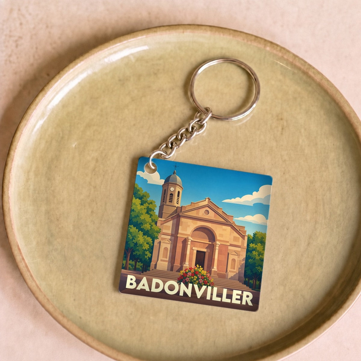 Porte-clés souvenir de la ville de Badonviller avec une illustration stylisée de son église.