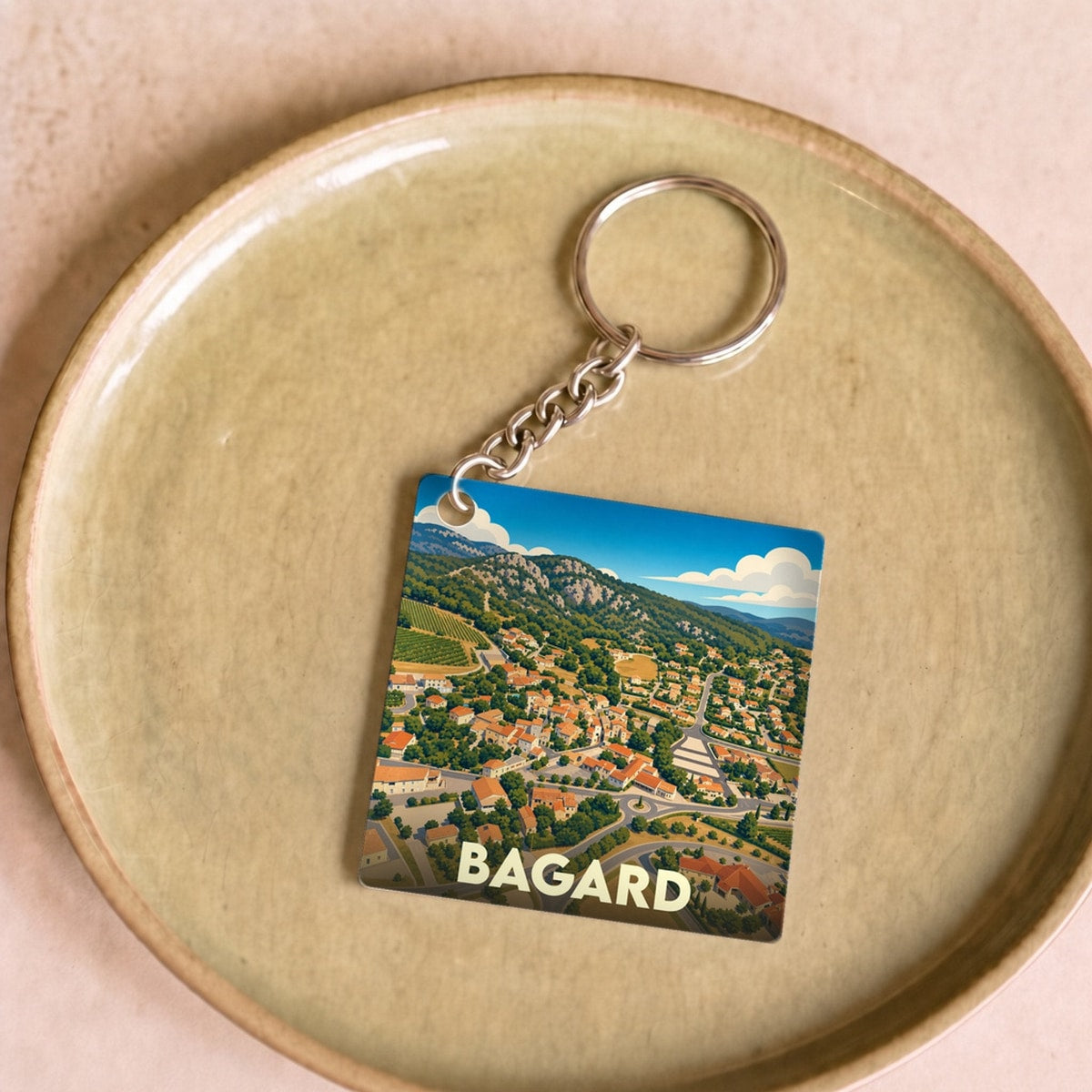 Porte-clés souvenir de la ville de Bagard avec une illustration stylisée vue du ciel.