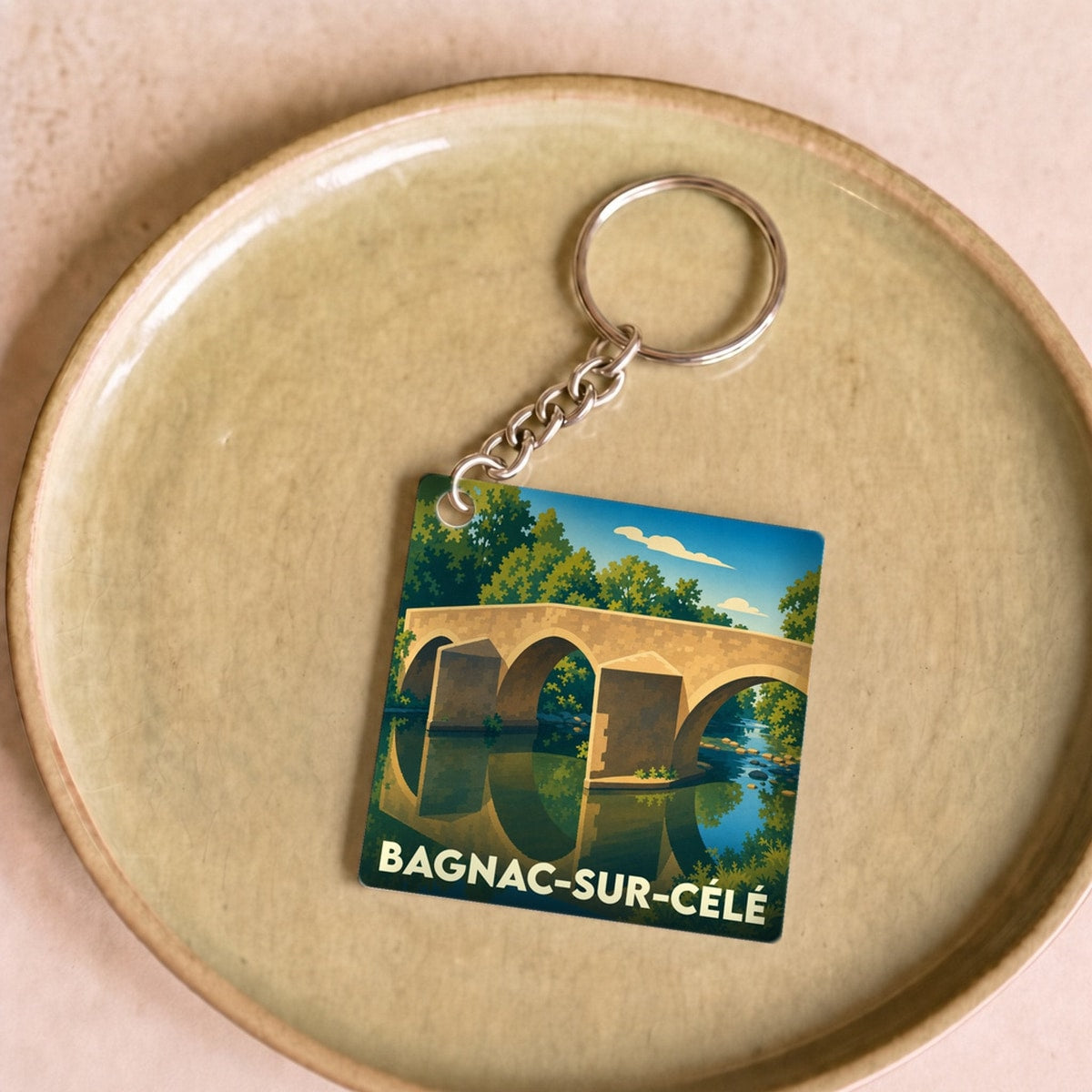 Porte-clés souvenir de la ville de Bagnac-sur-Célé avec une illustration stylisée d'un pont médiéval.