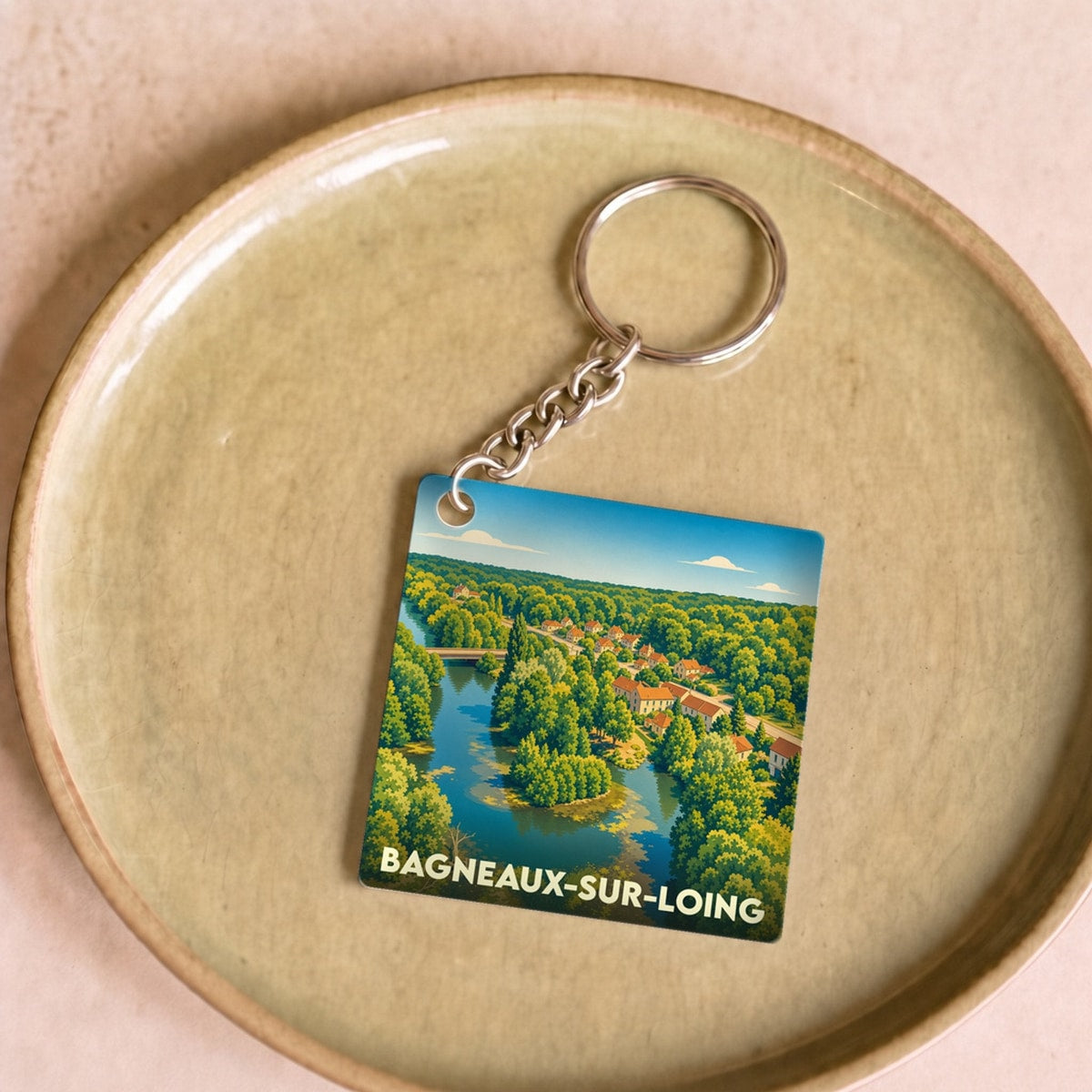 Porte-clés souvenir de la ville de Bagneaux-sur-Loing avec une illustration paysagère stylisée.