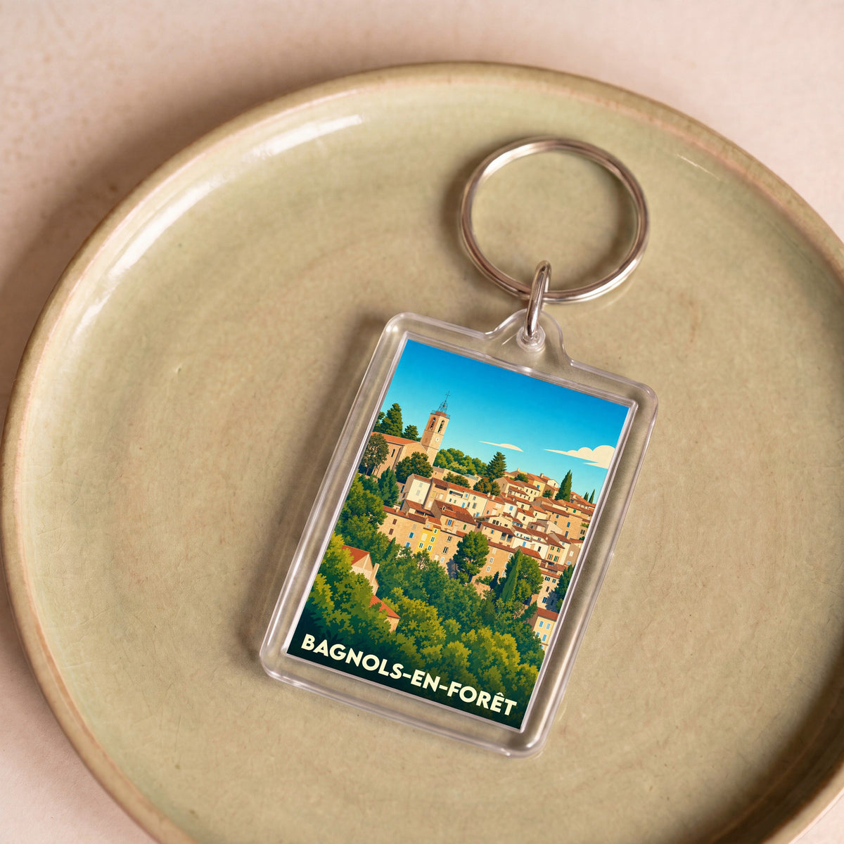 Porte-clés souvenir de la ville de Bagnols-en-Forêt avec une illustration stylisée.
