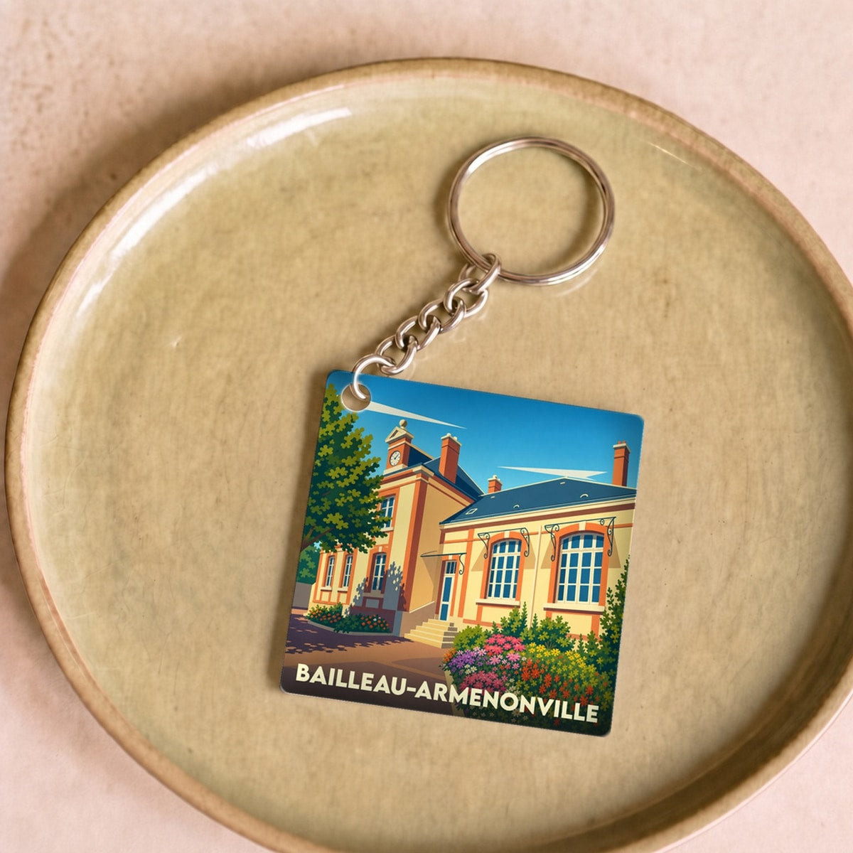 Porte-clés souvenir de la ville de Bailleau-Armenonville avec une illustration stylisée de sa mairie.