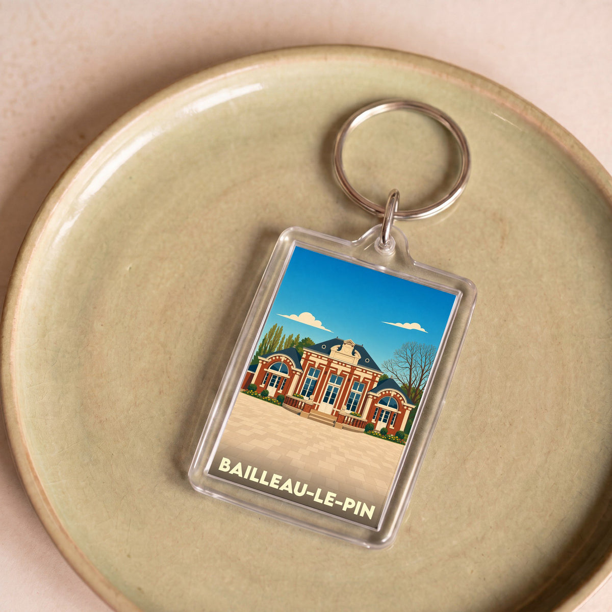 Porte-clés souvenir de la ville de Bailleau-le-Pin avec une illustration stylisée de sa mairie.