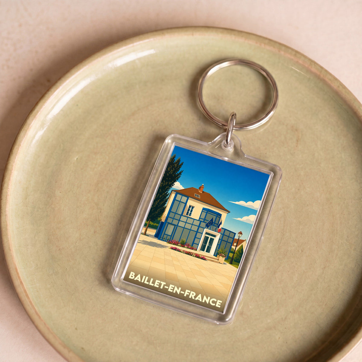 Porte-clés souvenir de la ville de Baillet-en-France avec une illustration stylisée de sa mairie.