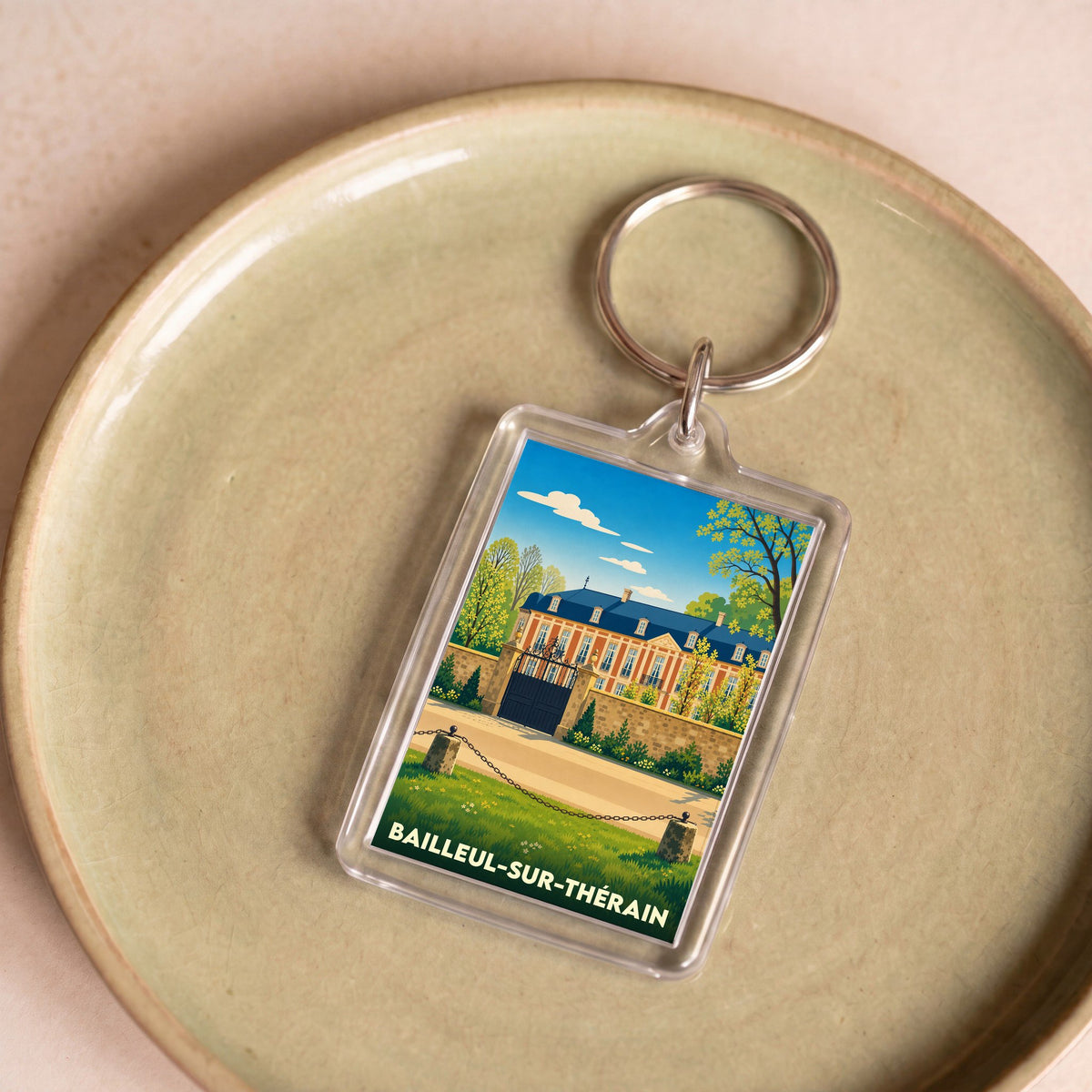 Porte-clés souvenir de la ville de Bailleul-sur-Thérain avec une illustration stylisée de son château.