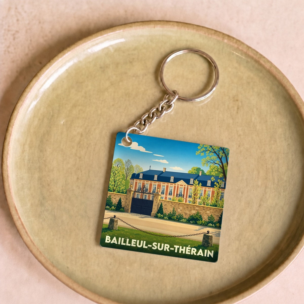 Porte-clés souvenir de la ville de Bailleul-sur-Thérain avec une illustration stylisée de son château.