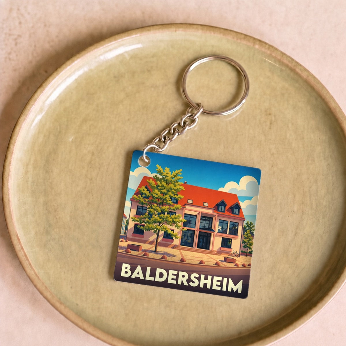 Porte-clés souvenir de la ville de Baldersheim avec une illustration stylisée.
