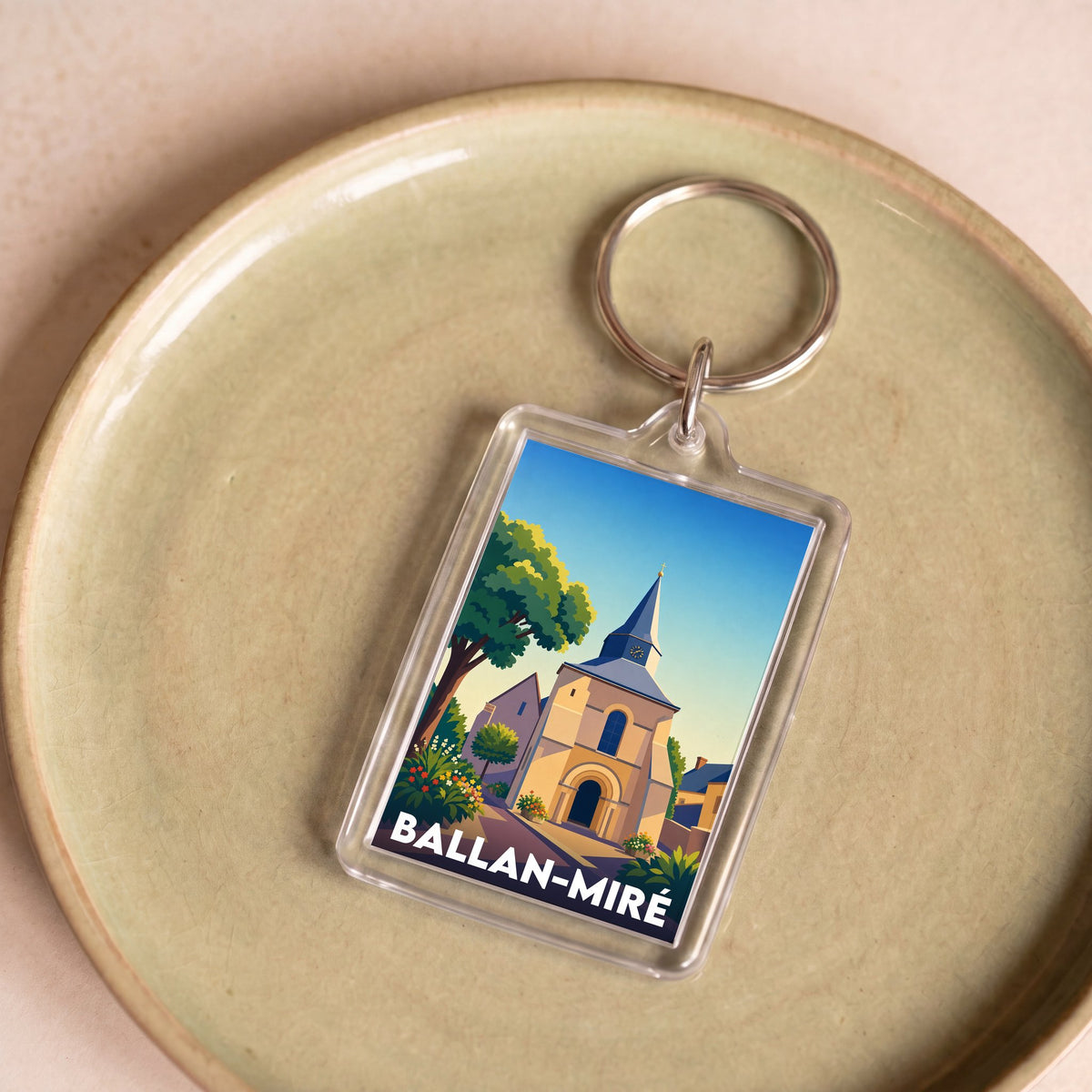 Porte-clés souvenir de la ville de Ballan-Miré avec une illustration stylisée de son église.