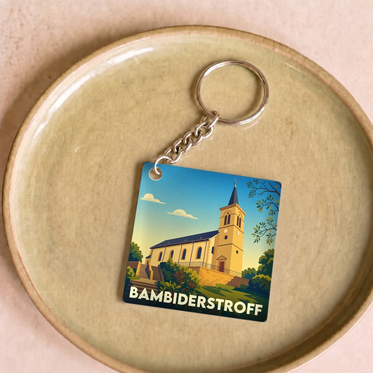 Porte-clés souvenir de la ville de Bambiderstroff avec une illustration stylisée de son église.