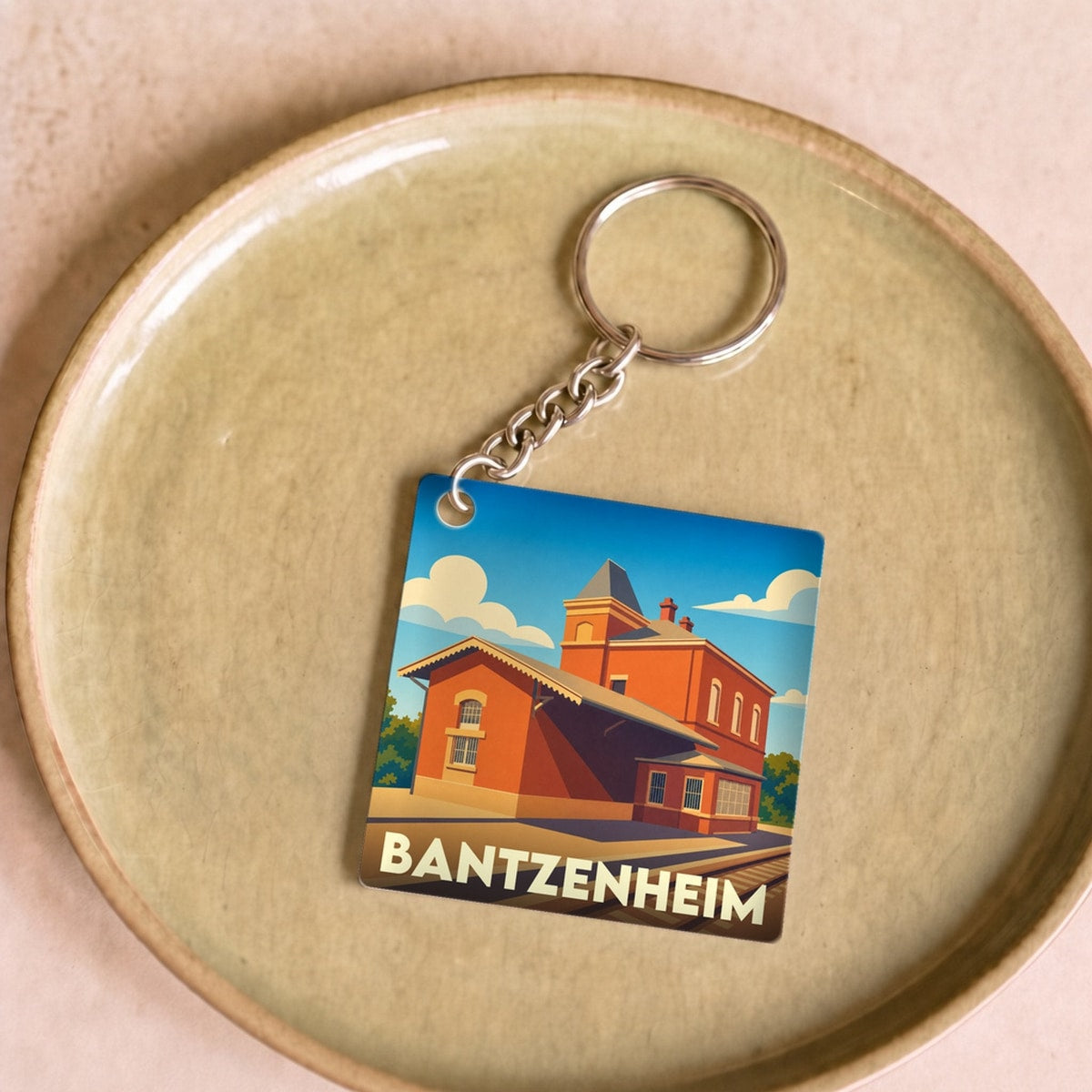 Porte-clés souvenir de la ville de Bantzenheim avec une illustration stylisée de sa gare.