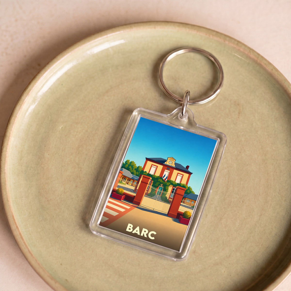 Porte-clés souvenir de la ville de Barc avec une illustration stylisée d'un bâtiment officiel.