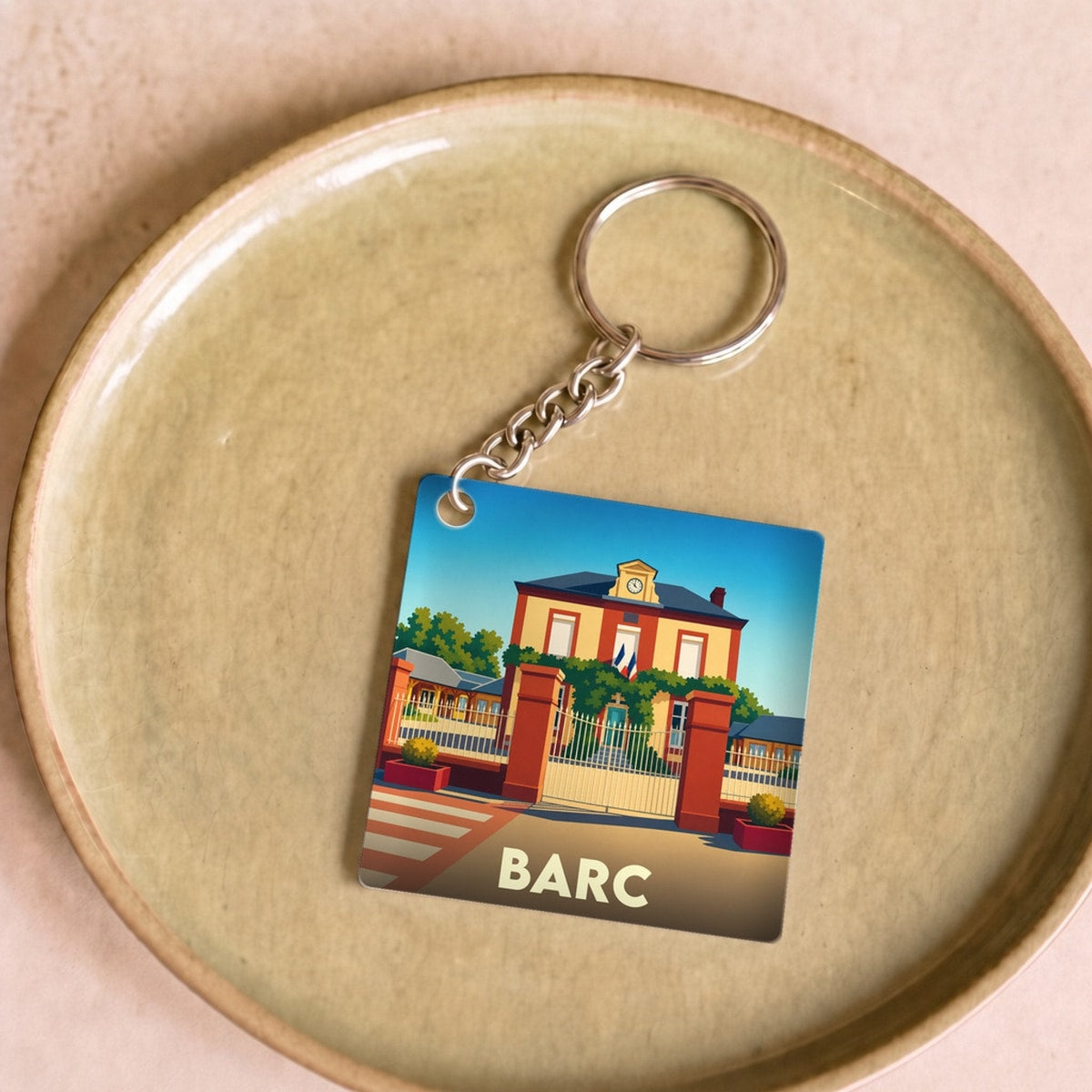 Porte-clés souvenir de la ville de Barc avec une illustration stylisée d'un bâtiment officiel.