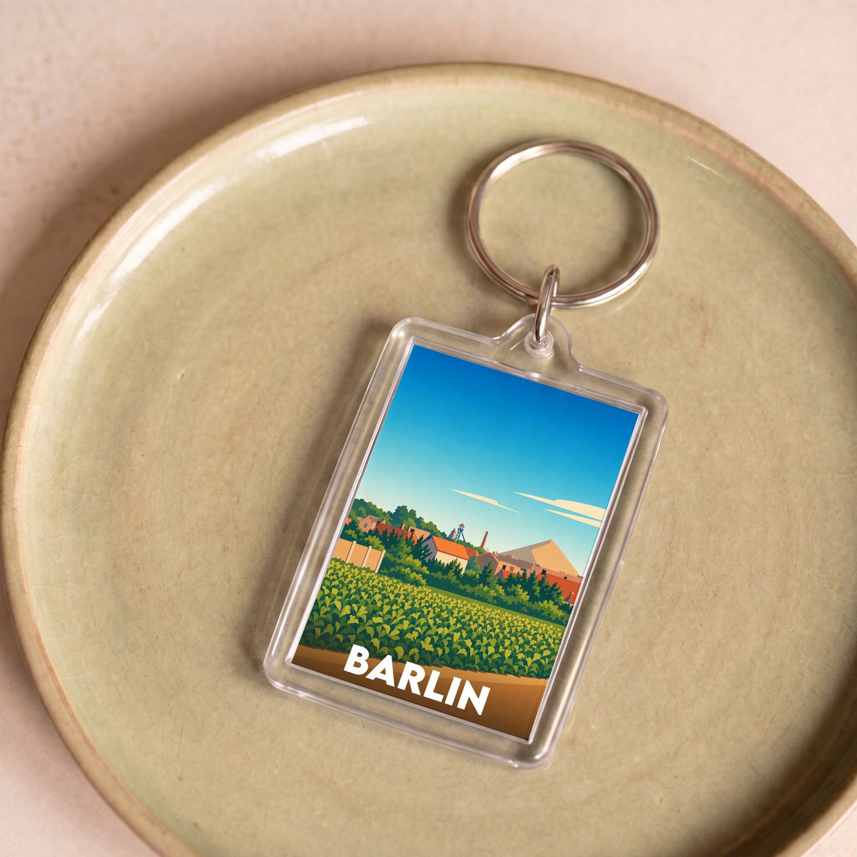 Porte-clés souvenir de la ville de Barlin avec une illustration stylisée de son paysage.
