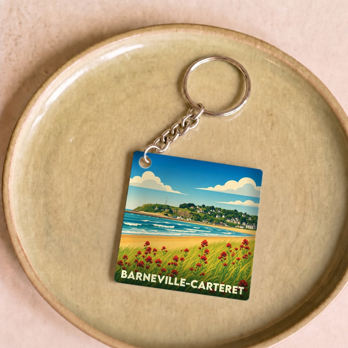 Porte-clés souvenir de la ville de Barneville-Carteret avec une illustration stylisée de sa côte.