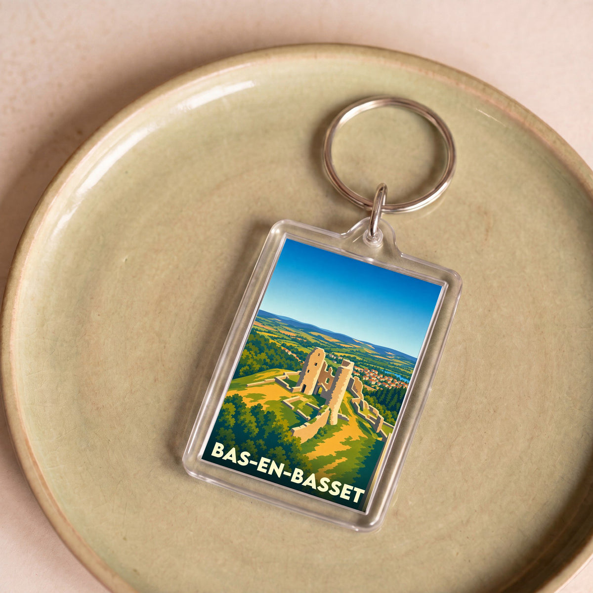 Porte-clés souvenir de la ville de Bas-en-Basset avec une illustration stylisée de son château médiéval.