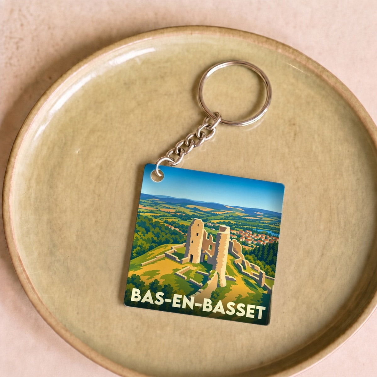 Porte-clés souvenir de la ville de Bas-en-Basset avec une illustration stylisée du Château de Rochebaron.