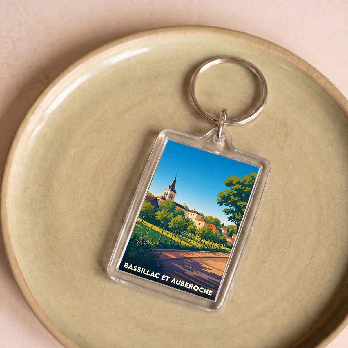 Porte-clés souvenir de la ville de Bassillac et Auberoche avec une illustration stylisée.