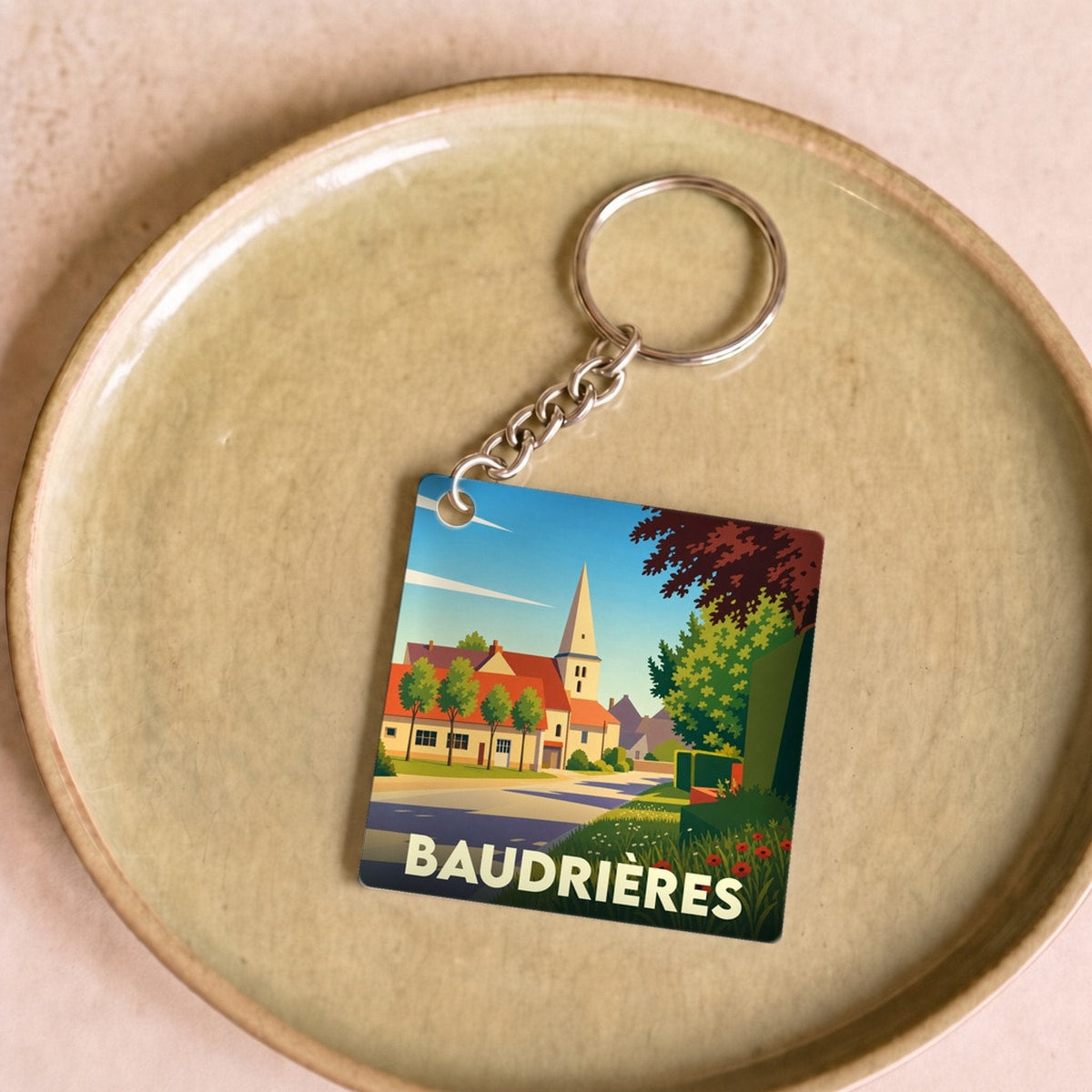 Porte-clés souvenir de la ville de Baudrières avec une illustration stylisée et colorée.