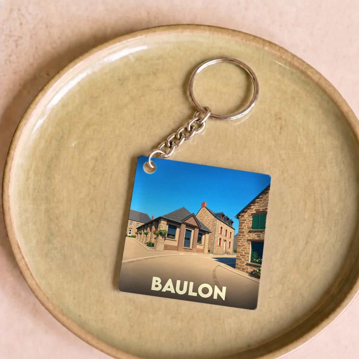 Porte-clés souvenir de la ville de Baulon avec une illustration stylisée.