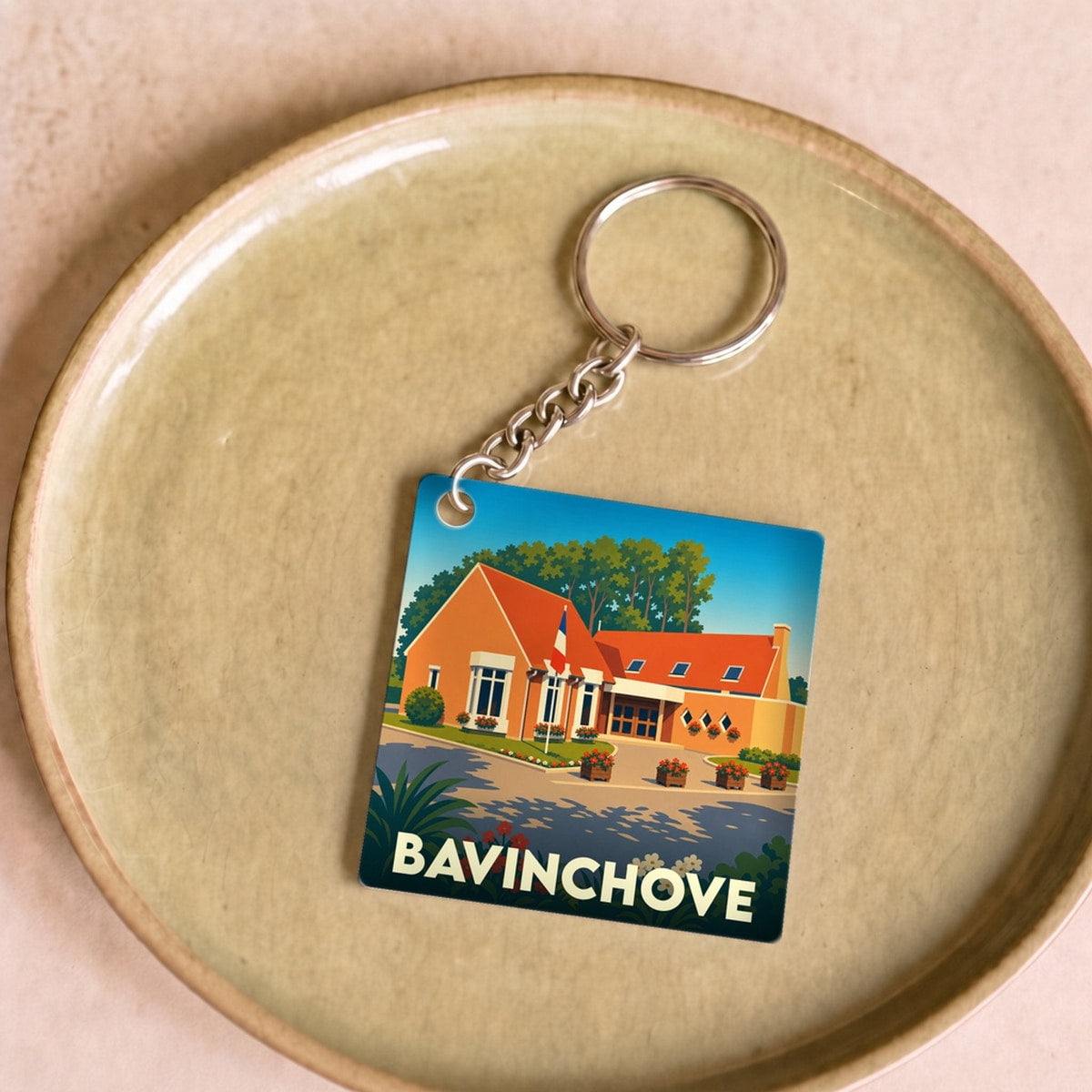 Porte-clés souvenir de la ville de Bavinchove avec une illustration stylisée d'une maison typique.