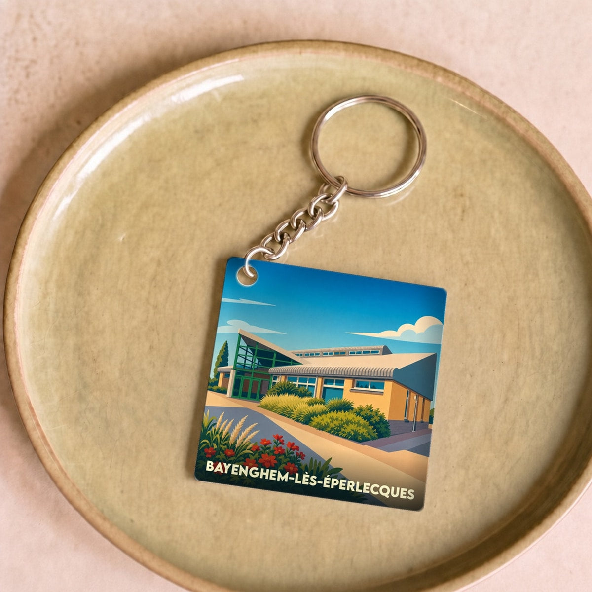 Porte-clés souvenir de la ville de Bayenghem-lès-Éperlecques avec une illustration stylisée.