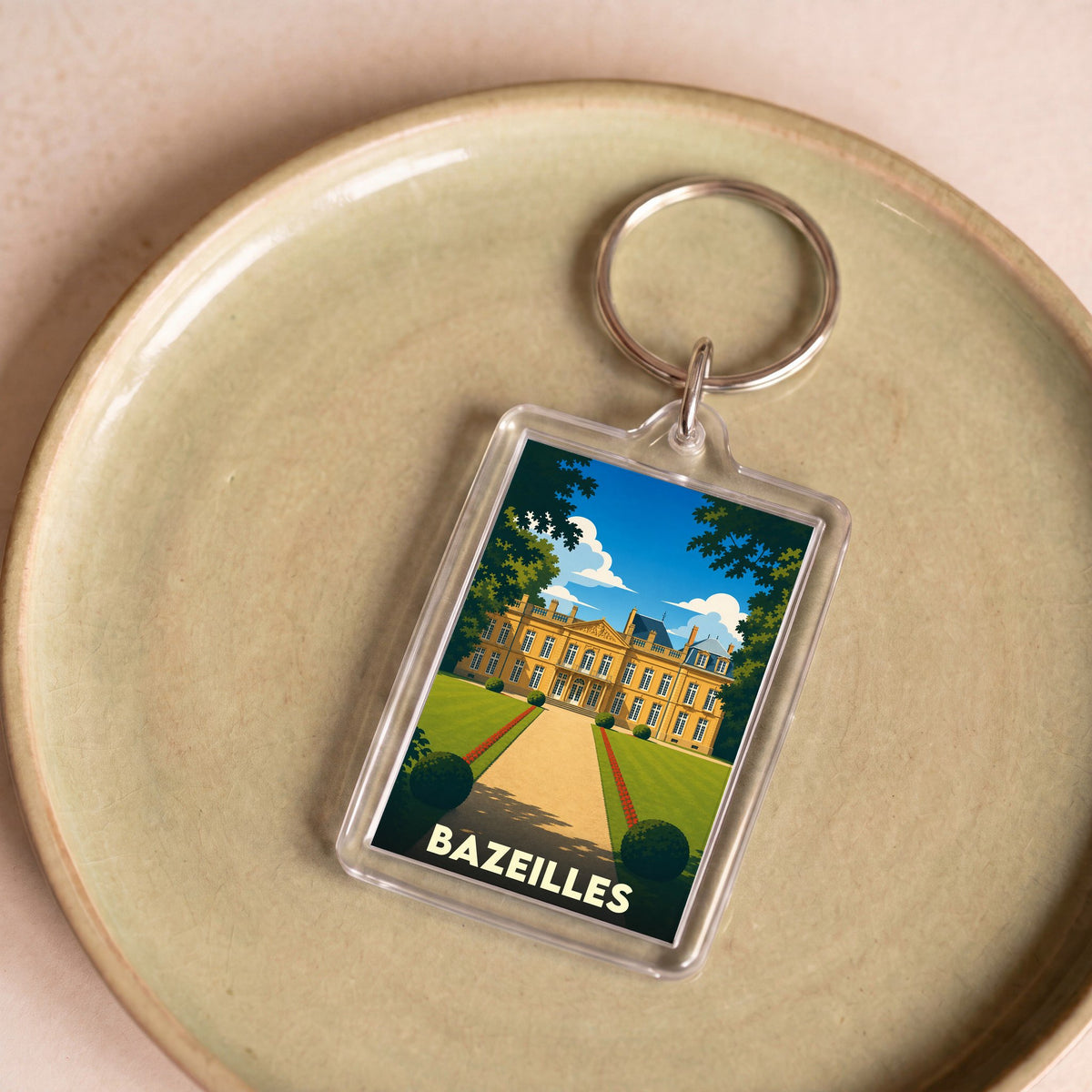 Porte-clés souvenir de la ville de Bazeilles avec une illustration stylisée d'un château.