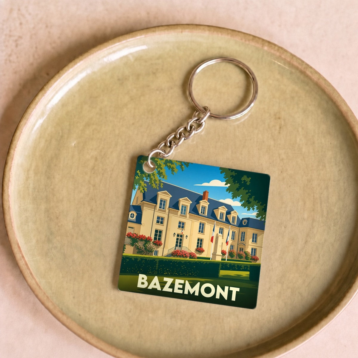 Porte-clés souvenir de la ville de Bazemont avec une illustration stylisée d'un château.