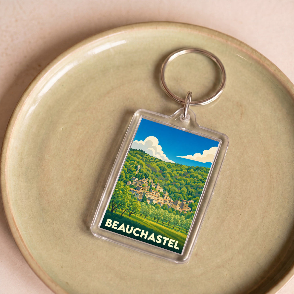 Porte-clés souvenir de la ville de Beauchastel avec une illustration stylisée d'un village perché.