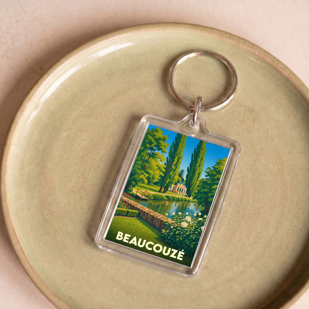 Porte-clés souvenir de la ville de Beaucouzé avec une illustration stylisée d'un parc paysager.