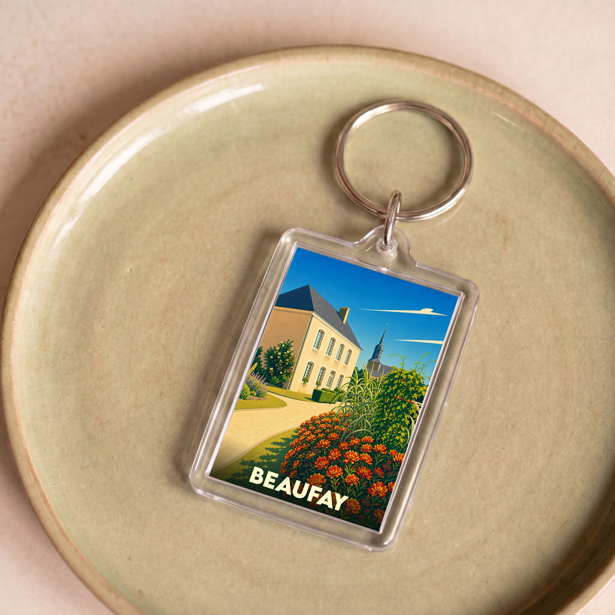 Porte-clés souvenir de la ville de Beaufay avec une illustration stylisée.