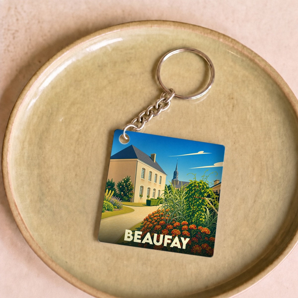 Porte-clés souvenir de la ville de Beaufay avec une illustration stylisée.