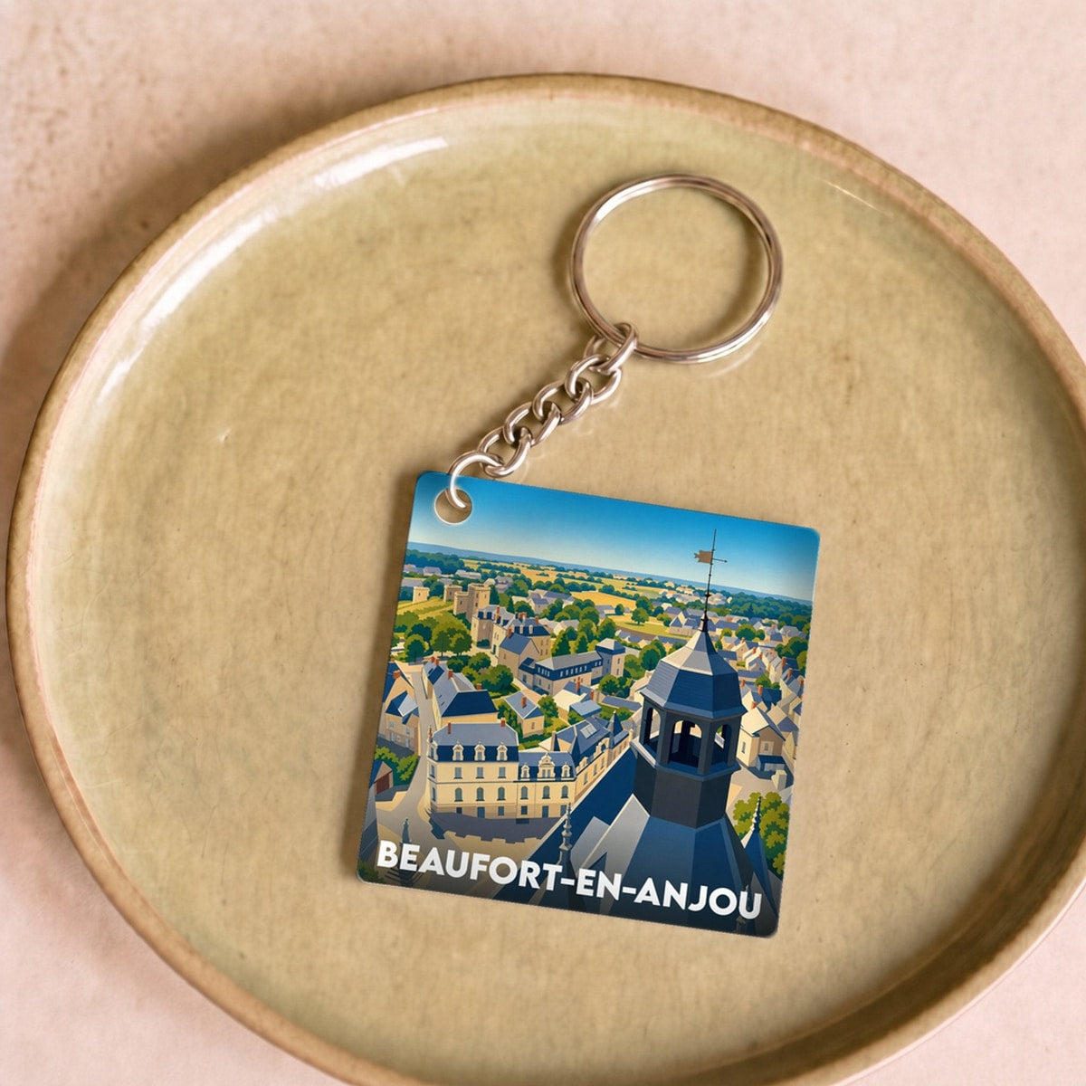 Porte-clés souvenir de la ville de Beaufort-en-Anjou avec une illustration stylisée.