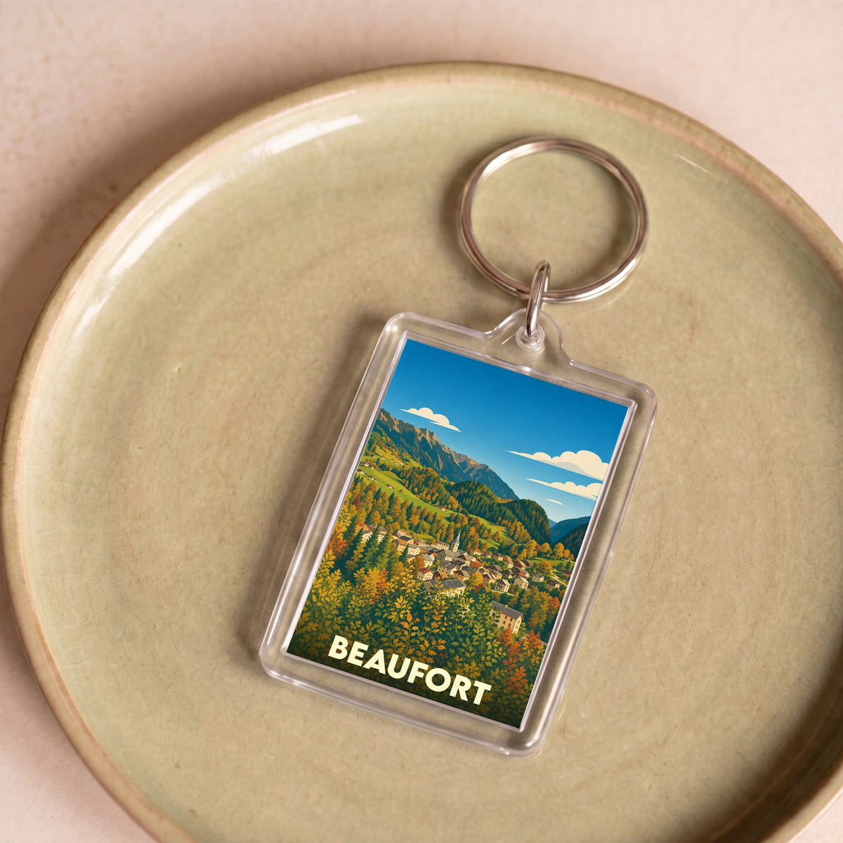 Porte-clés souvenir de la ville de Beaufort avec une illustration stylisée d'un paysage montagneux.