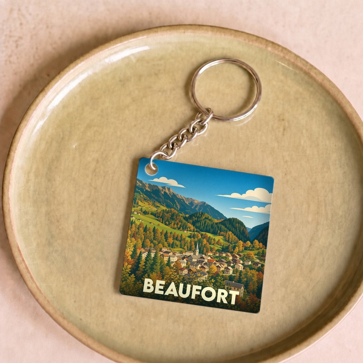 Porte-clés souvenir de la ville de Beaufort avec une illustration stylisée d'un paysage montagneux.