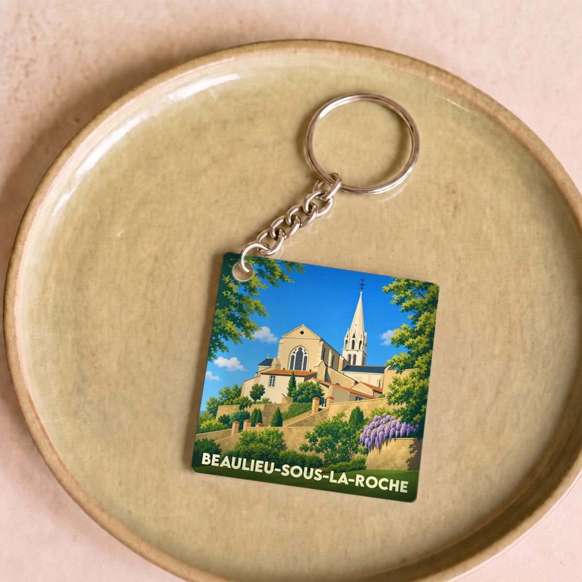 Porte-clés souvenir de la ville de Beaulieu-sous-la-Roche avec une illustration stylisée.