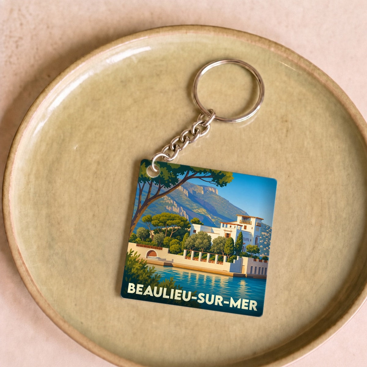 Porte-clés souvenir de la ville de Beaulieu-sur-Mer avec une illustration stylisée du littoral.