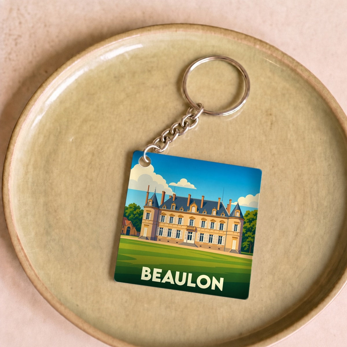 Porte-clés souvenir de la ville de Beaulon avec une illustration stylisée de château.
