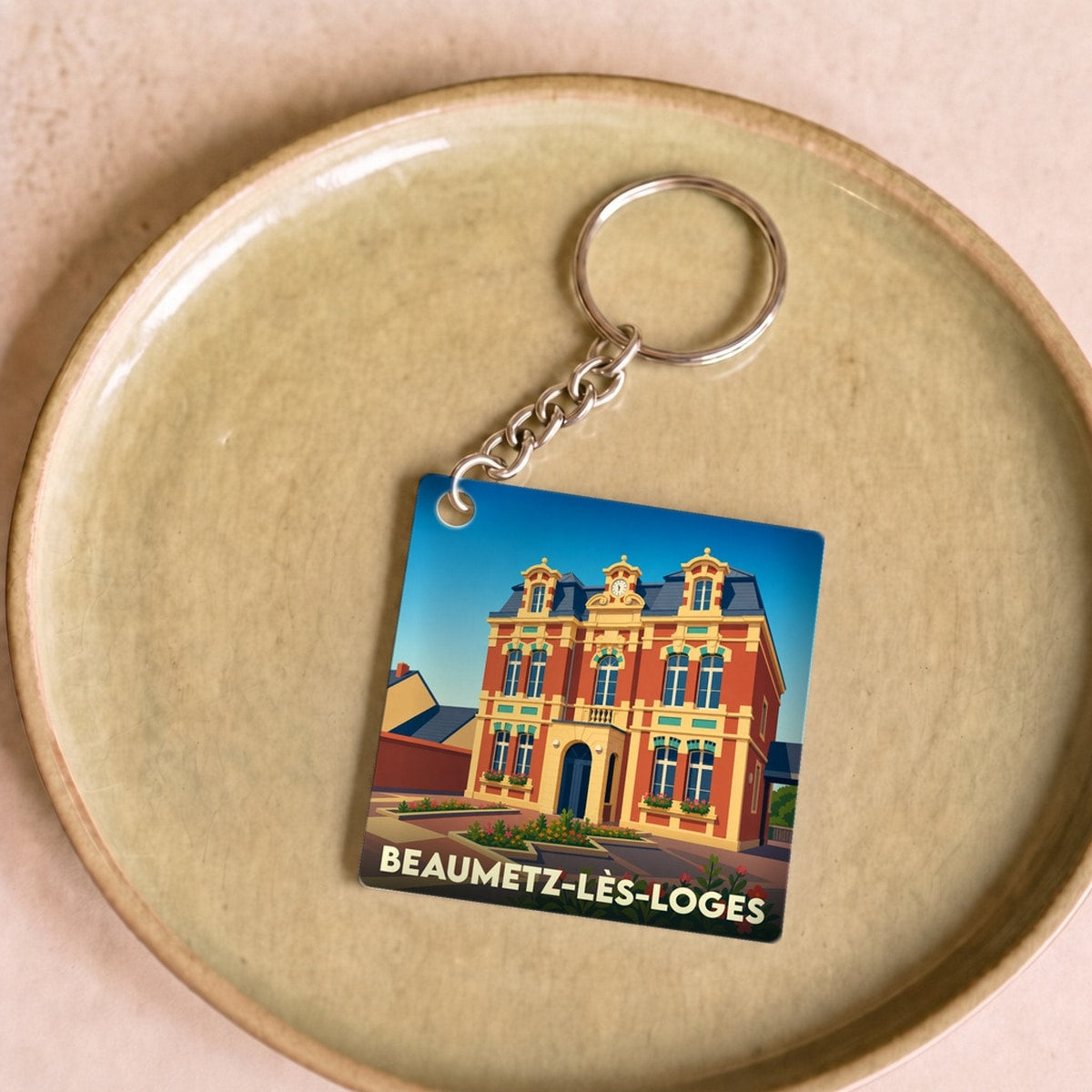 Porte-clés souvenir de la ville de Beaumetz-lès-Loges avec une illustration stylisée de son hôtel de ville.